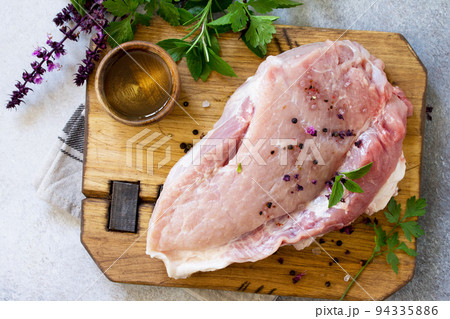 Fresh raw meat. Raw pork meat fillet with olive oil, spices and herbs on wooden table. Top view flat lay background. Fresh raw meat. Raw pork meat fillet with olive oil, spices and herbs on wooden table. Top view flat lay background. 94335886