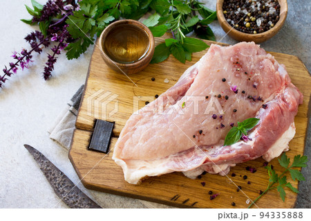 Fresh raw meat. Raw pork meat fillet with olive oil, spices and herbs on wooden table. Copy space. Fresh raw meat. Raw pork meat fillet with olive oil, spices and herbs on wooden table. Copy space. 94335888
