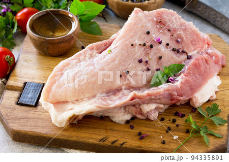 Fresh raw meat. Raw pork meat fillet with olive oil, spices and herbs on wooden table. Fresh raw meat. Raw pork meat fillet with olive oil, spices and herbs on wooden table. 94335891