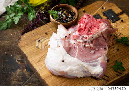 Fresh raw meat. Raw pork meat steak with olive oil, spices and herbs on wooden table. Copy space. Fresh raw meat. Raw pork meat steak with olive oil, spices and herbs on wooden table. Copy space. 94335940