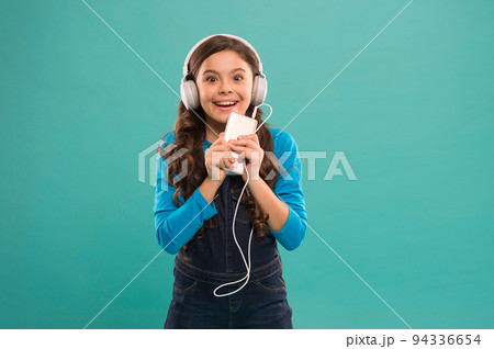 she is so happy. happy little girl. schoolgirl use digital device. casual fashion for kids. kid long hair listen music in headset. small child make play list on smartphone. small girl use mp3 player she is so happy. happy little girl. schoolgirl use digital device. casual fashion for kids. kid long hair listen music in headset. small child make play list on smartphone. small girl use mp3 player 94336654