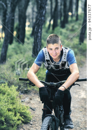 Teenager in forest with downhill bike. 94337677