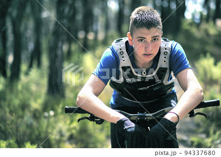 Teenager in forest with downhill bike. 94337680