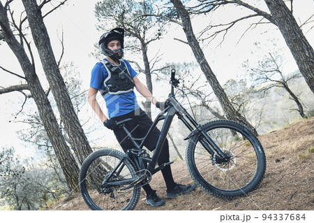 Teenager in forest practicing downhill biking. 94337684