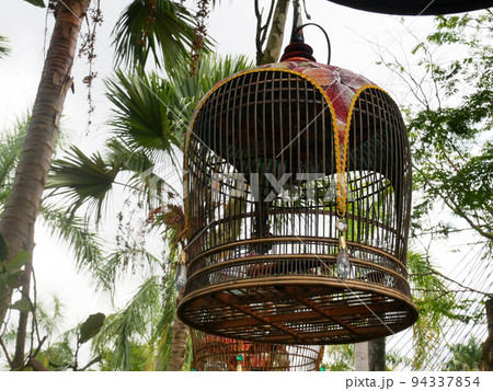 MELAKA, MALAYSIA -JUNE 7, 2022: Traditional bird cages made of bamboo are hung in an open area. Has a fabric cover to protect the bird inside from the weather. Displayed for exhibition. 94337854