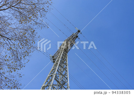 Bottom view of a power transmission tower against the sky 94338305