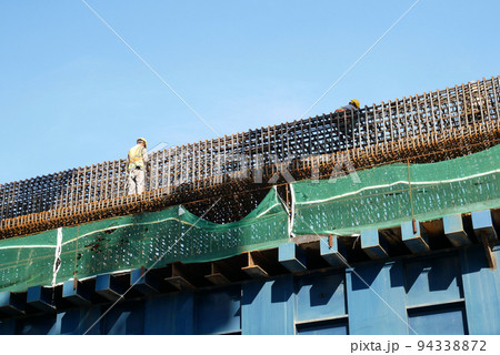 MELAKA, MALAYSIA - JUNE 5, 2022: Construction workers work at height and wear safety gear to ensure their safety. They work in groups and carry out their specific tasks. 94338872