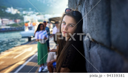Woman leaning next to stone wall closeup photo 94339381