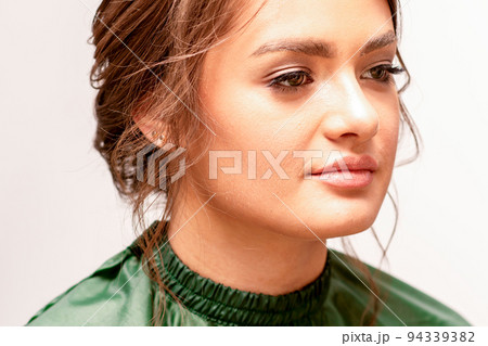 The fashionable young woman. Portrait of the beautiful female model with long hair and makeup. Beauty young caucasian woman with a brown curly hairstyle The fashionable young woman. Portrait of the beautiful female model with long hair and makeup. Beauty young caucasian woman with a brown curly hairstyle 94339382