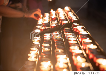 Several candles lined up in church closeup 94339836