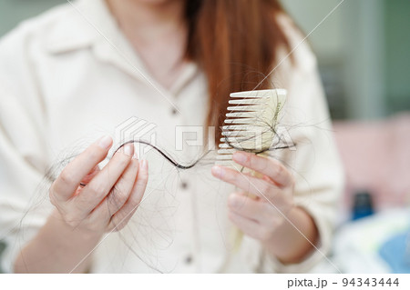 Asian woman have problem with long hair loss attach in her hand. Asian woman have problem with long hair loss attach in her hand. 94343444