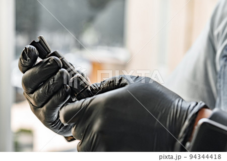The gunsmith maintaining his rifle in a workshop The gunsmith maintaining his rifle in a workshop 94344418