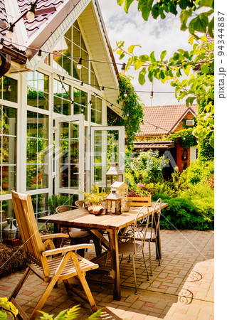 wooden table in the courtyard of the country house with retro decor elements. 94344887