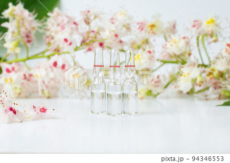 Bottle of horse chestnut extract, essence of chestnut flowers. Flowering branches and leaves of horse chestnut. Bottle of horse chestnut extract, essence of chestnut flowers. Flowering branches and leaves of horse chestnut. 94346553