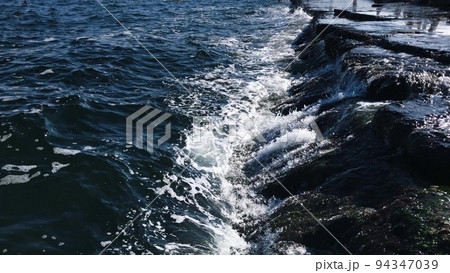 Spectacular tidal bore, a wave rolled on the rocks. 94347039