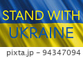 Stand with Ukraine text on the waving flag of Ukraine. 94347094