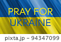 Pray for Ukraine text on the waving flag of Ukraine. 94347099