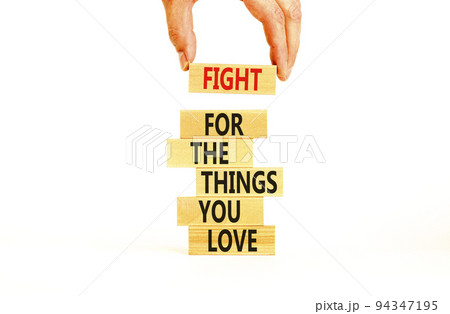 Fight for love symbol. Concept words Fight for the things you love on wooden blocks on a beautiful white table white background. Businessman hand. Business motivational and fight for love concept. 94347195