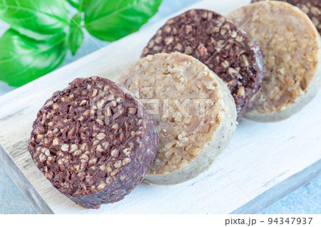 Traditional Irish and British black pudding and white or oatmeal pudding sausage on wooden board Traditional Irish and British black pudding and white or oatmeal pudding sausage on wooden board 94347937