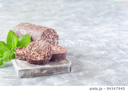 Traditional Irish and British black pudding sausage slices on a wooden board, horizontal, copy space Traditional Irish and British black pudding sausage slices on a wooden board, horizontal, copy space 94347940