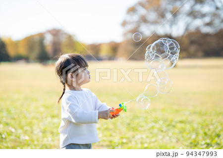 シャボン玉で遊ぶ女の子 94347993