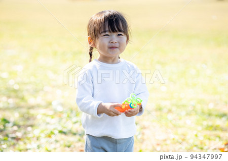 シャボン玉で遊ぶ女の子 94347997