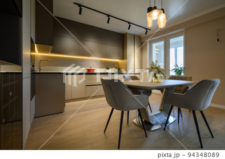 Modern grey luxurious kitchen with dining table in studio apartment 94348089