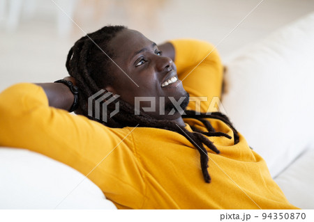 Home Rest. Portrait Of Smiling Young Black Man Leaning Back On Couch 94350870