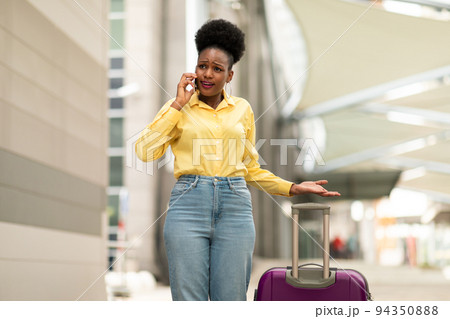 African Lady Traveler Talking On Cellphone Having Problem At Airport 94350888