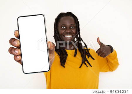 Positive Young Black Guy Holding Blank Smartphone And Showing Thumb Up Gesture 94351054