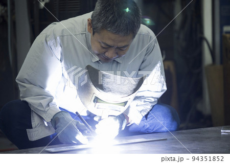 溶接工イメージ　空調作業服を着て溶接をするミドル男性作業員 94351852