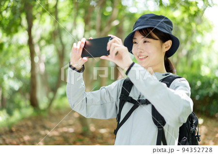 スマートフォンで写真を撮る山ガール スマートフォンで写真を撮る山ガール 94352728