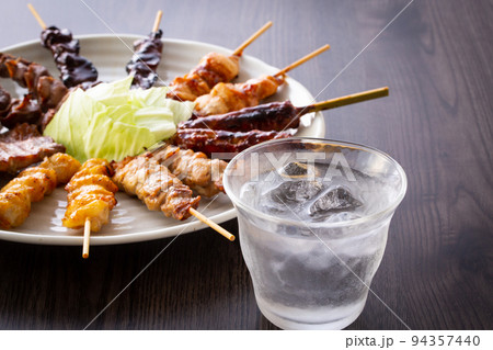 居酒屋の焼酎と焼鳥盛り合せ 94357440