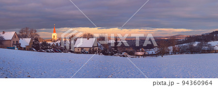 winter landscape with village, evening light illuminating the church, Vezovata Plane, Czech republic 94360964