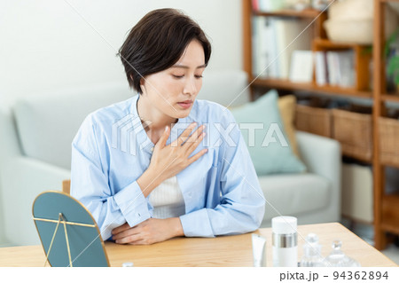 リビングで胸に手を当てる女性 94362894