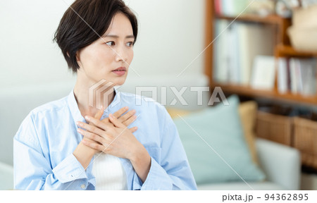 リビングで胸に手を当てる女性 94362895