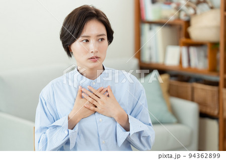 リビングで胸に手を当てる女性 94362899