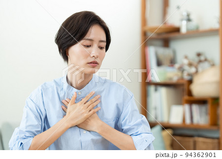 リビングで胸に手を当てる女性 94362901