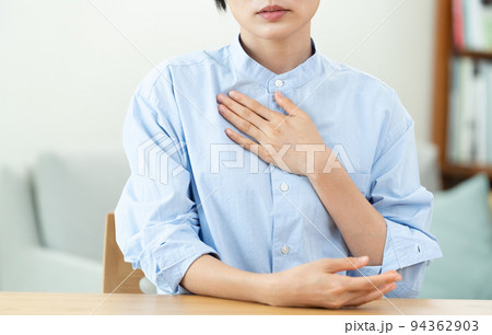 リビングで胸に手を当てる女性 94362903