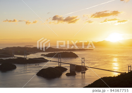夏の愛媛県瀬戸内海大島の亀老山展望台公園から見た夕陽のしまなみ海道と来島海峡大橋の風景 94367755