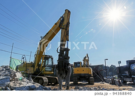 解体工事現場の重機と輝く太陽 解体工事現場の重機と輝く太陽 94368840