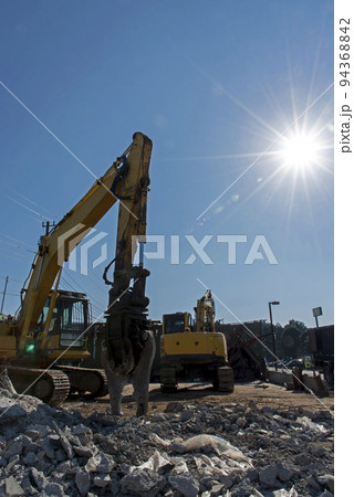 解体工事現場の重機と輝く太陽 解体工事現場の重機と輝く太陽 94368842