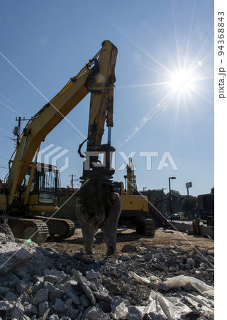 解体工事現場の重機と輝く太陽 94368843