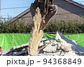 解体したコンクリートスラブを持ち上げる解体重機 94368849