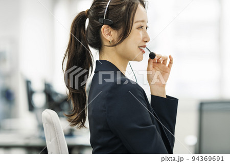 電話対応するコールセンターの女性 電話対応するコールセンターの女性 94369691