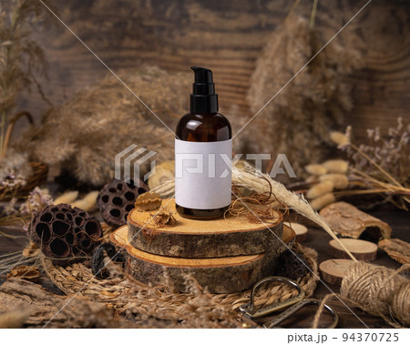 Cosmetic one pump bottle on wood near natural boho decorations close up. Label Mockup 94370725