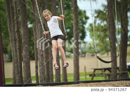 Young pretty excited teenage girl jumping out of the swings on summer vacations sunny day. Danger of accident concept Young pretty excited teenage girl jumping out of the swings on summer vacations sunny day. Danger of accident concept 94371267