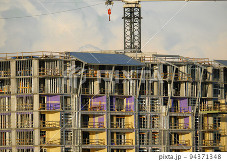 Tower lifting cranes at high residential apartment buildings construction site. Real estate development Tower lifting cranes at high residential apartment buildings construction site. Real estate development 94371348
