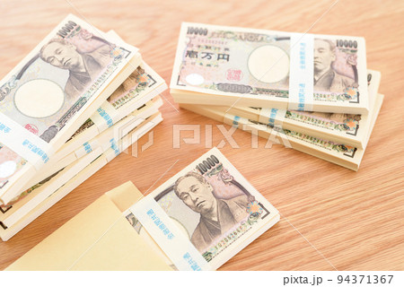 茶封筒に入った百万円の札束と積まれた札束　日本円 94371367