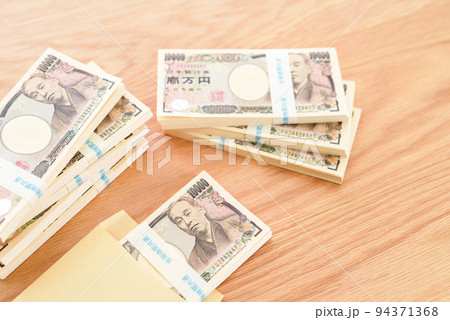 茶封筒に入った百万円の札束と積まれた札束　日本円 94371368
